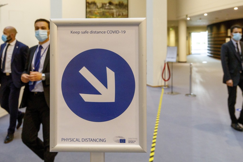 Visitors and employees wearing face masks in the hallway of the European Parliament in Brussels. Photo: AP