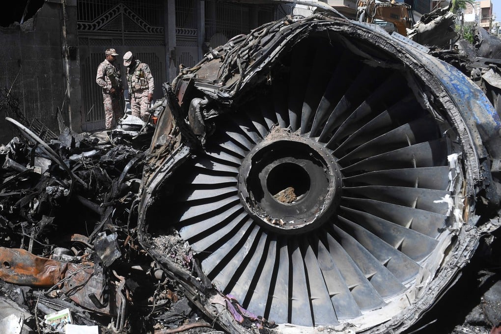 Pakistani security personnel amid the wreckage of the plane that crashed in Karachi. Photo: AFP
