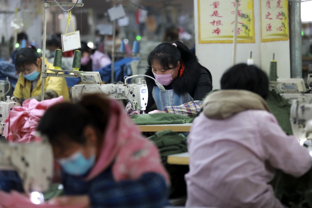 Workers wearing protective face masks work at a garment factory in Suixi county in central China’s Anhui province on February 21. Photo: AP