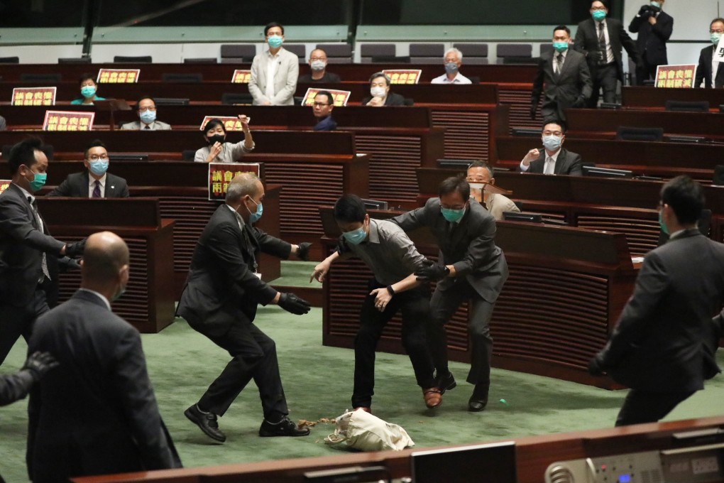 Democratic Party legislator Ted Hui Chi-fung throws what he says is a bottle of rotten plants during a debate in the Legislative Council on May 28. Photo: Nora Tam