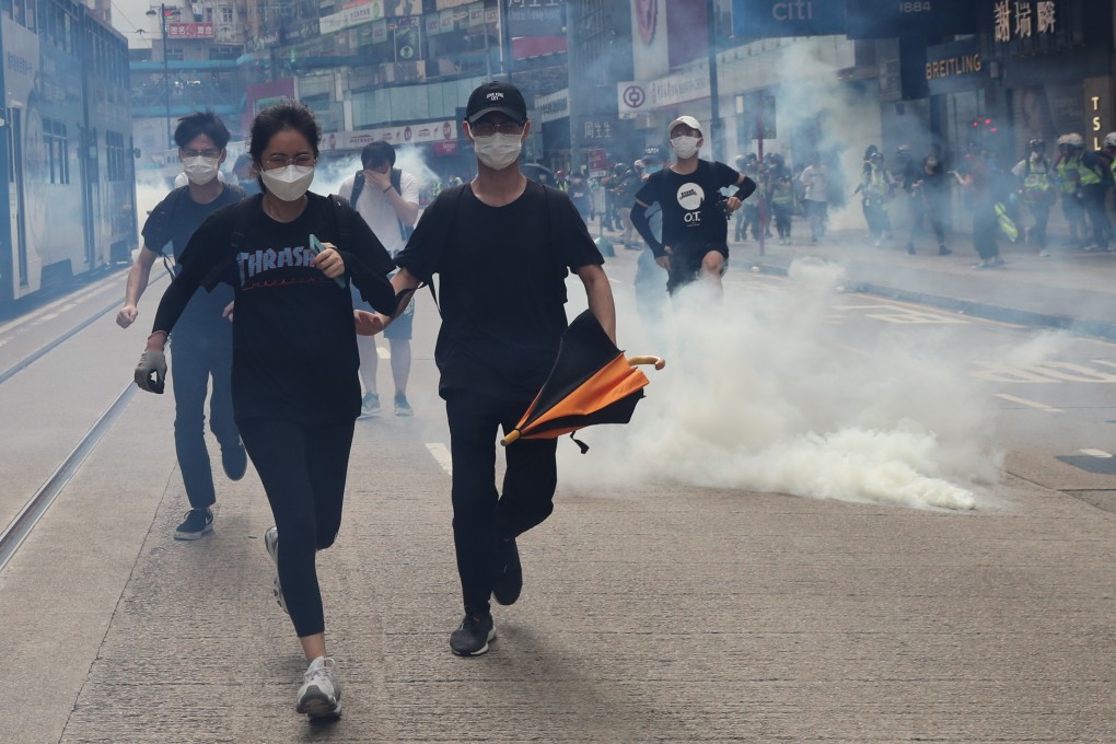 Protesters run from tear gas fired by riot police during a march against the proposed national security law in Causeway Bay, Hong Kong, on Sunday. Photo: Sam Tsang