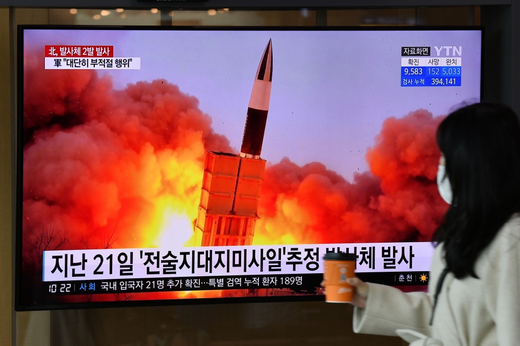A woman walks past a screen showing file footage of a North Korean missile test at a railway station in Seoul in March. Photo: AFP