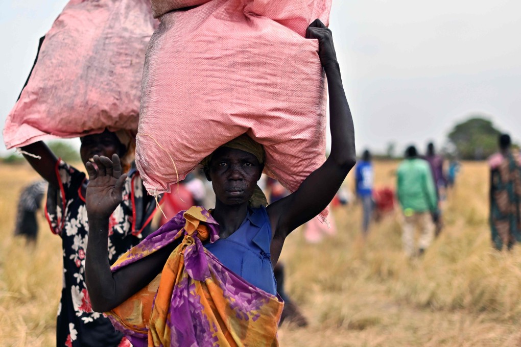 Villagers in South Sudan collect bags of grain and supplementary aid air-dropped by the World Food Programme in February. Photo: AFP