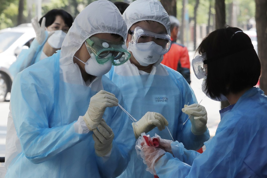 Medical staff wearing protective suits gather samples from people during Covid-19 testing at a hospital in Seoul, South Korea. Photo: AP