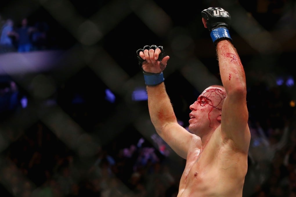 Georges St-Pierre celebrates his victory over Michael Bisping at UFC 217. Photo: AFP