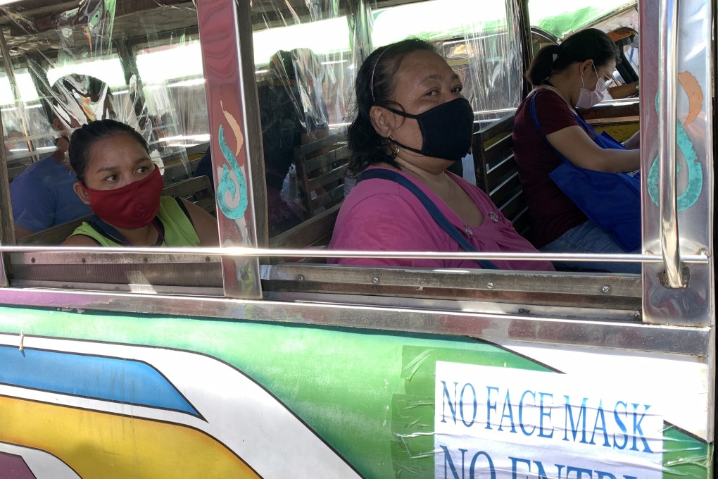 Philippine passengers wear masks as they ride a mini bus, known as a jeepney. Photo: EPA