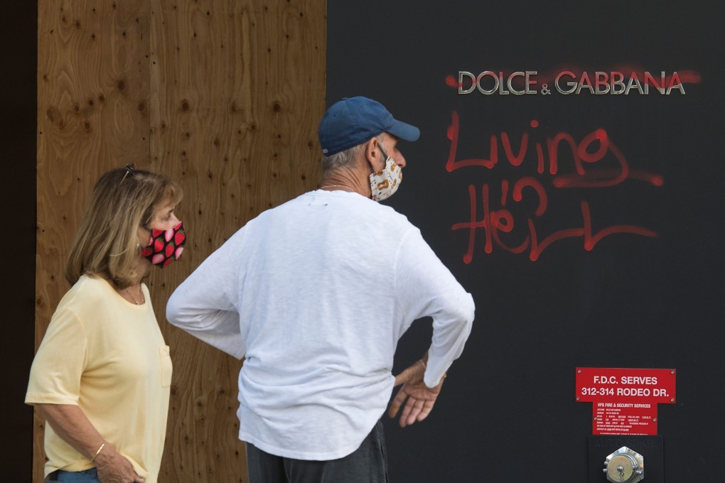 People view graffiti outside a Dolce & Gabbana store on Rodeo Drive in Beverly Hills, Los Angeles. Protests sparked by the death of African-American George Floyd at the hands of police in the US city of Minneapolis have led to looting and vandalism, including of luxury stores. Photo: AFP)