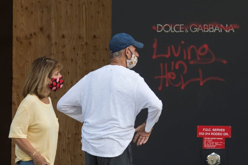 People view graffiti outside a Dolce & Gabbana store on Rodeo Drive in Beverly Hills, Los Angeles. Protests sparked by the death of African-American George Floyd at the hands of police in the US city of Minneapolis have led to looting and vandalism, including of luxury stores. Photo: AFP)