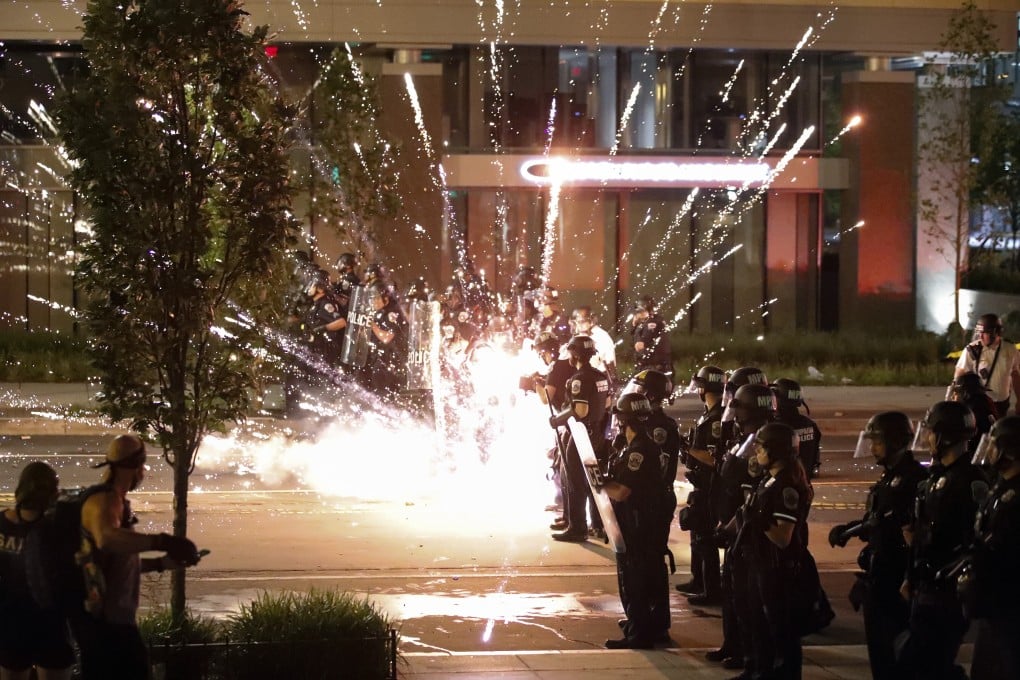A firework explodes near a police line as demonstrators protest the death of George Floyd near the White House in Washington. Photo: AP
