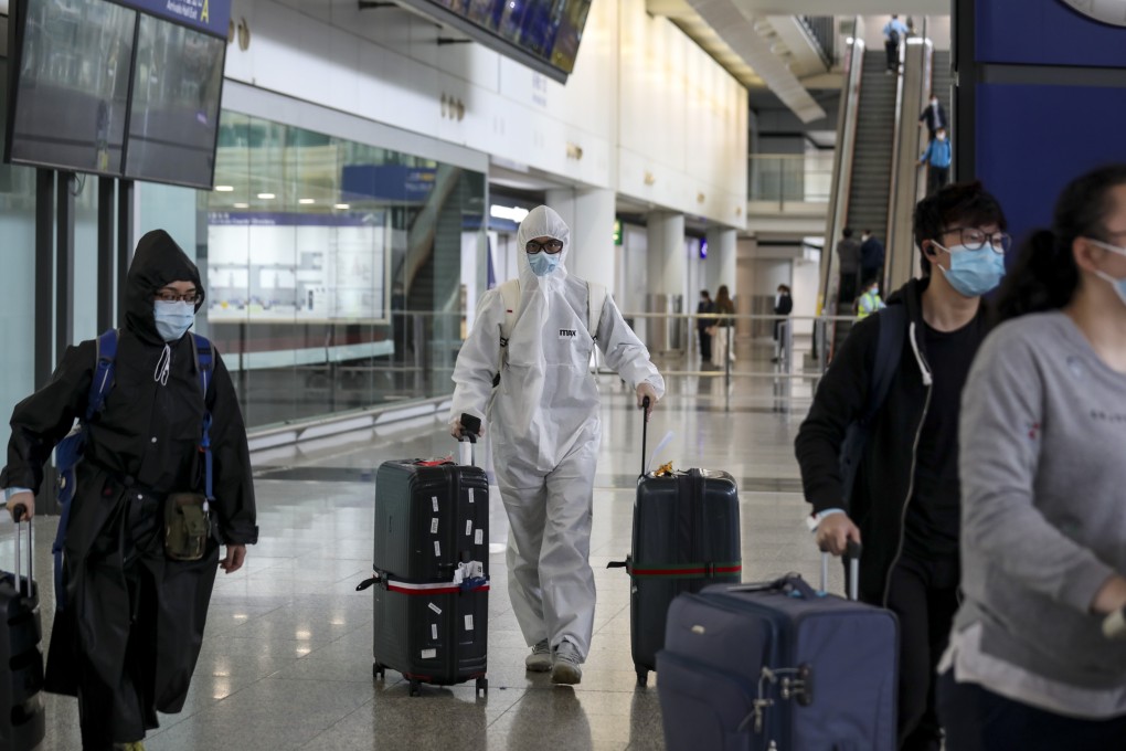 Travellers wearing protective gear walk through Hong Kong airport on March 21. All inbound passengers currently have to proceed to Asia-World Expo to have their saliva samples tested for the Covid-19 virus. Photo: Xiaomei Chen