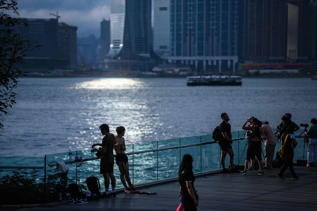People gather to watch the sunset from a viewing platform in Tamar Park overlooking Victoria Harbour in Hong Kong, on May 5. The economic downturn means Hong Kong’s fresh graduates may have to settle for lower-quality and low-paying jobs, which could potentially undermine their self-esteem. Photo: AFP