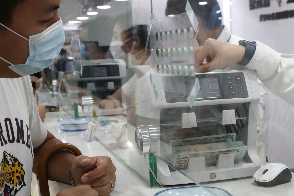 A man exchanges Hong Kong dollars for US dollars at a money changer in Sham Shui Po on May 29. People have been exchanging Hong Kong dollars in fear of the currency dropping in light of the new national security law. Photo: Edmond So