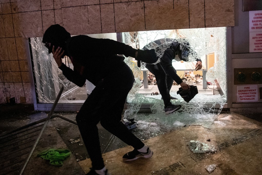People take items from a damaged store in the Manhattan, New York City. Photo: Reuters