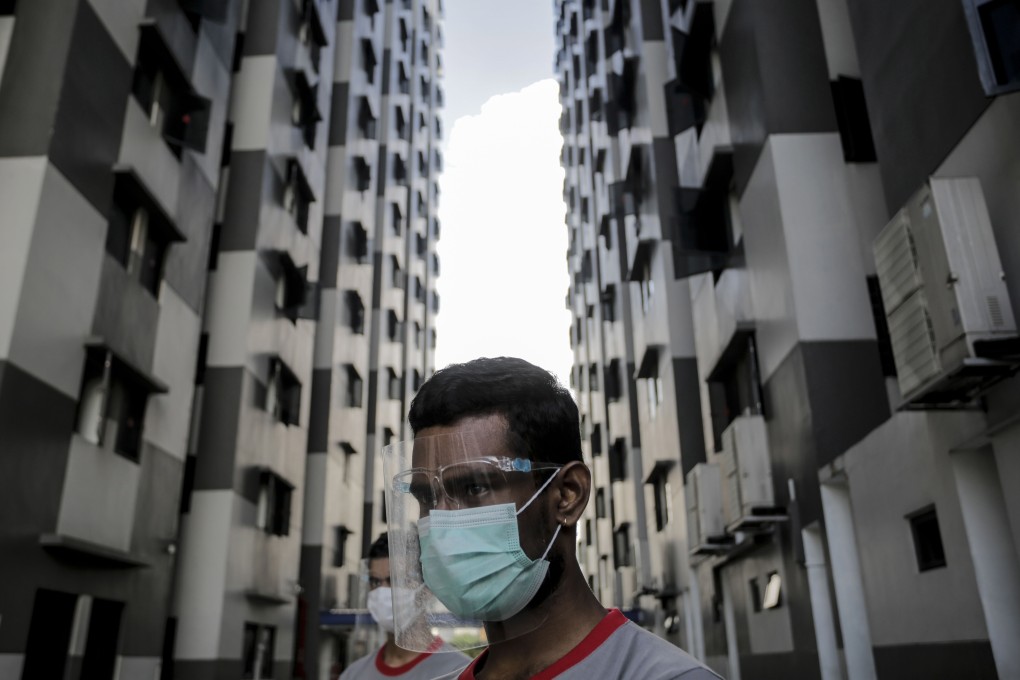 A worker wears a protective visor and surgical mask at the Westlite Papan foreign worker dormitory in Singapore. Photo: EPA