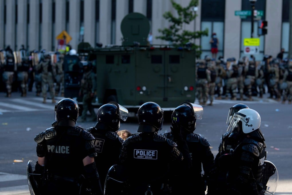 Riot police hold people back as US President Donald Trump visits St John’s Church in Washington. Photo: AFP