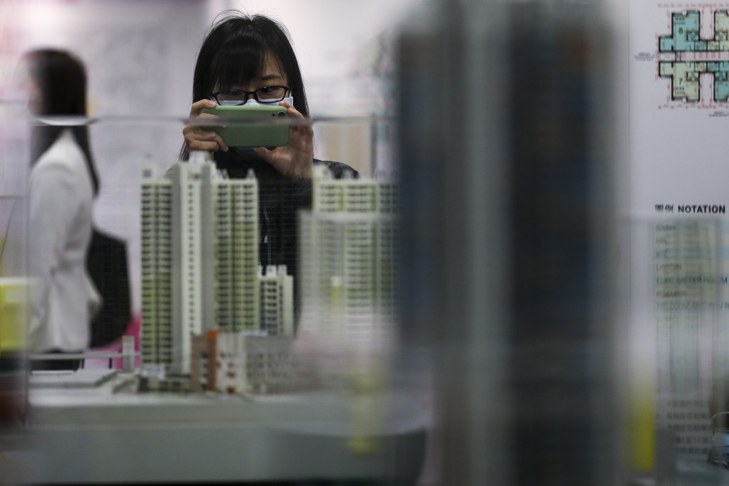 A potential homebuyer wearing a protective face mask looks at a scale model of Home Ownership Scheme (HOS) flats displayed by the Housing Authority in Lok Fu, amid the novel coronavirus epidemic. Photo: Winson Wong