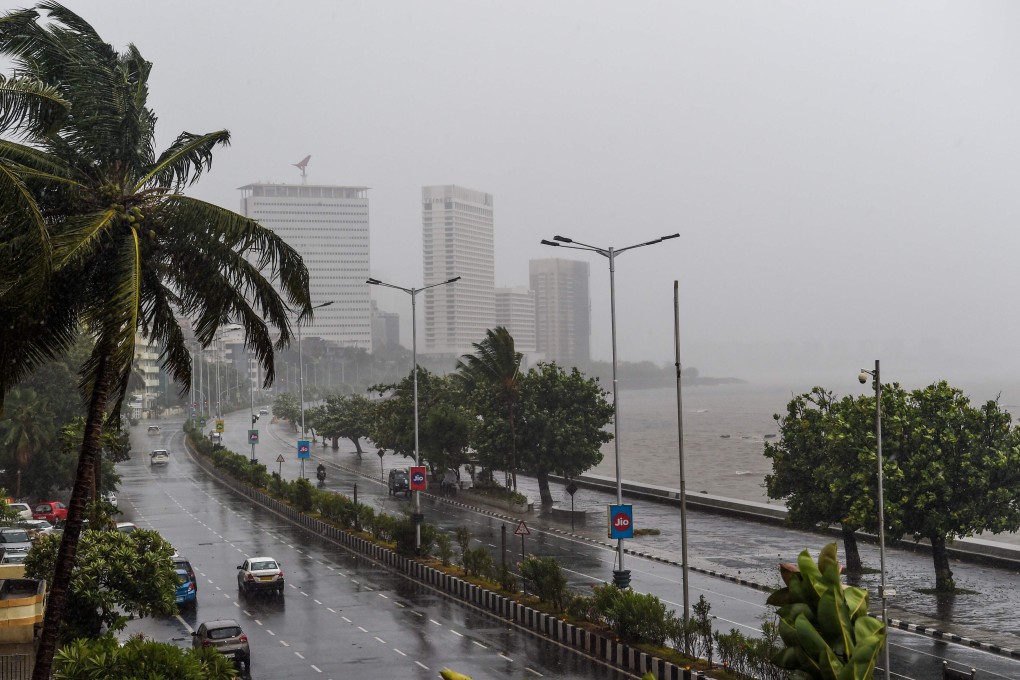 Motorists drive on a road near the Marine Drive under heavy rain in Mumbai. Photo: AFP
