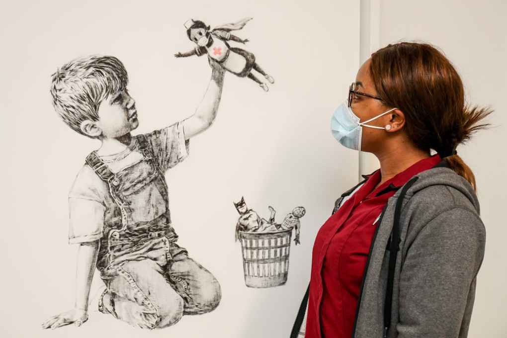 An employee of University Hospital Southampton takes in an artwork by street artist Banksy called Game Changer on May 7. People have shown great willingness to make sacrifices for the sake of health care and other essential workers. Photo: AFP/ University Hospital Southampton
