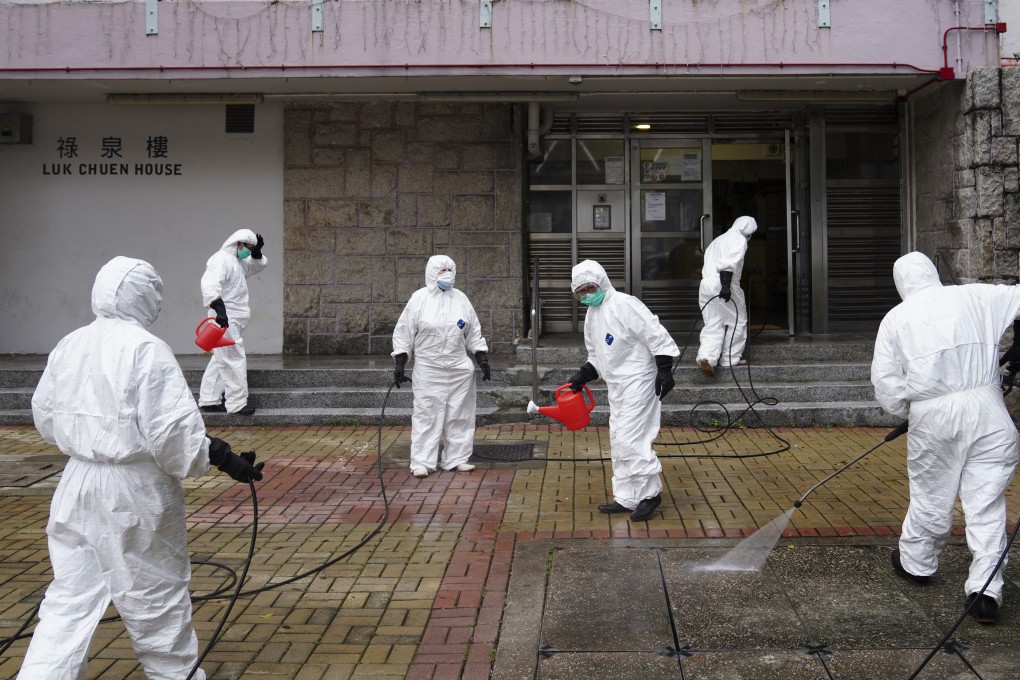 Workers in protective gear disinfect Luk Chuen House, at Lek Yuen Estate, in Sha Tin. Photo: Sam Tsang