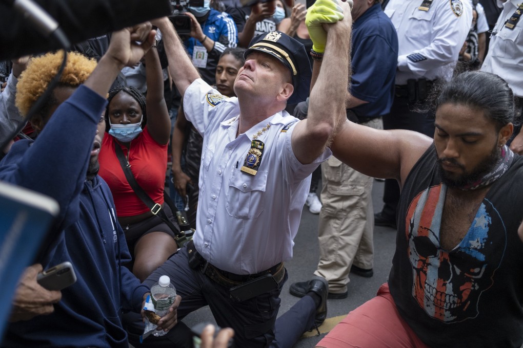 Chief of Department of the New York City Police, Terence Monahan, takes a knee with activists in New York. Photo: AP