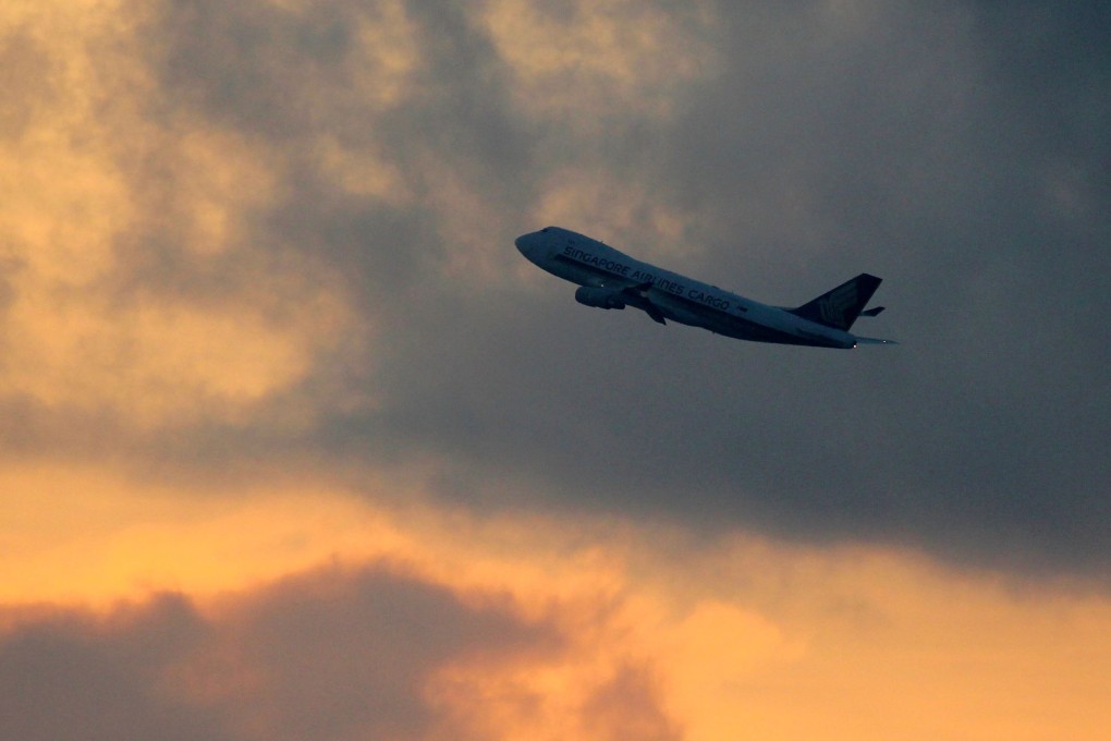 A Singapore Airlines plane flies out of Changi International Airport at sunrise on Sunday. Photo: AFP