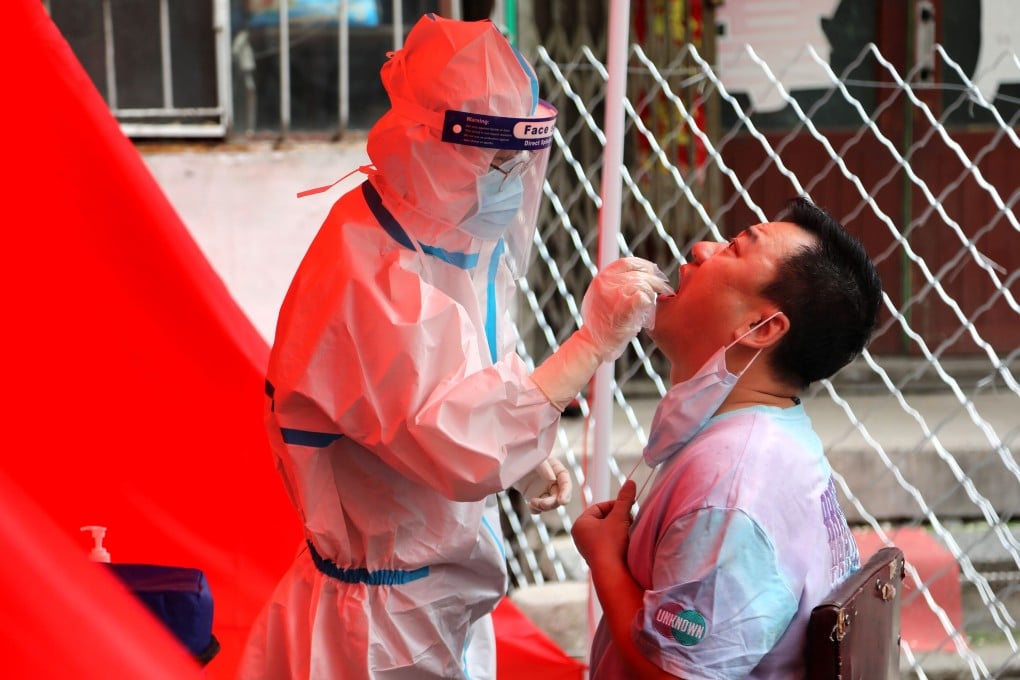 A medical worker takes a sample from a resident in Mudanjiang as the city begins mass screening for the coronavirus. Photo: AFP