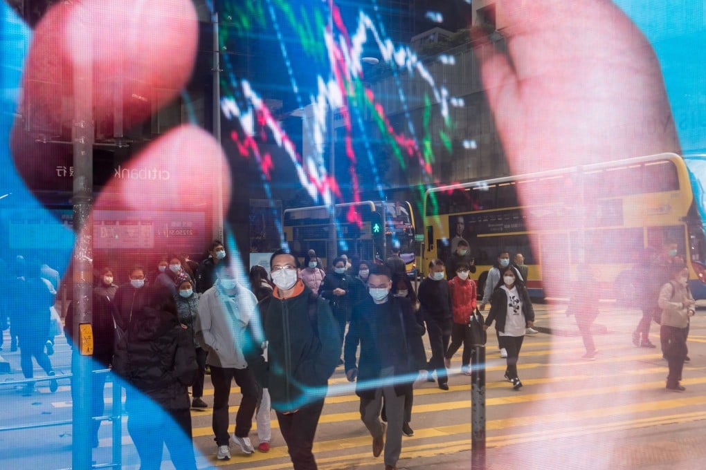 Pedestrians wearing protective masks are reflected in an advertisement as they cross a road in the Central district of Hong Kong on January 29. Investors should be prepared for more threats to the status quo. Photo: Bloomberg