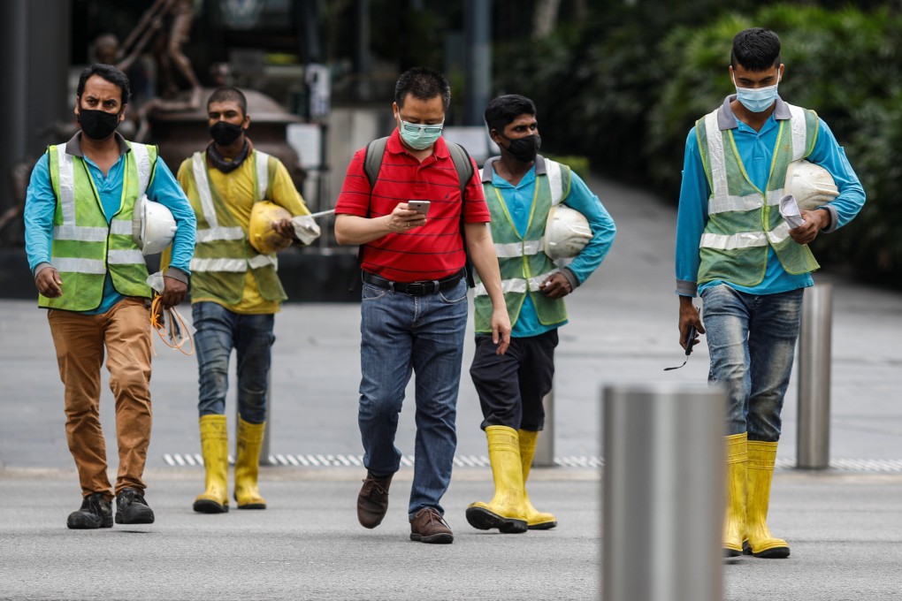 Migrant workers cross a street at Orchard Road in Singapore. Photo: Reuters