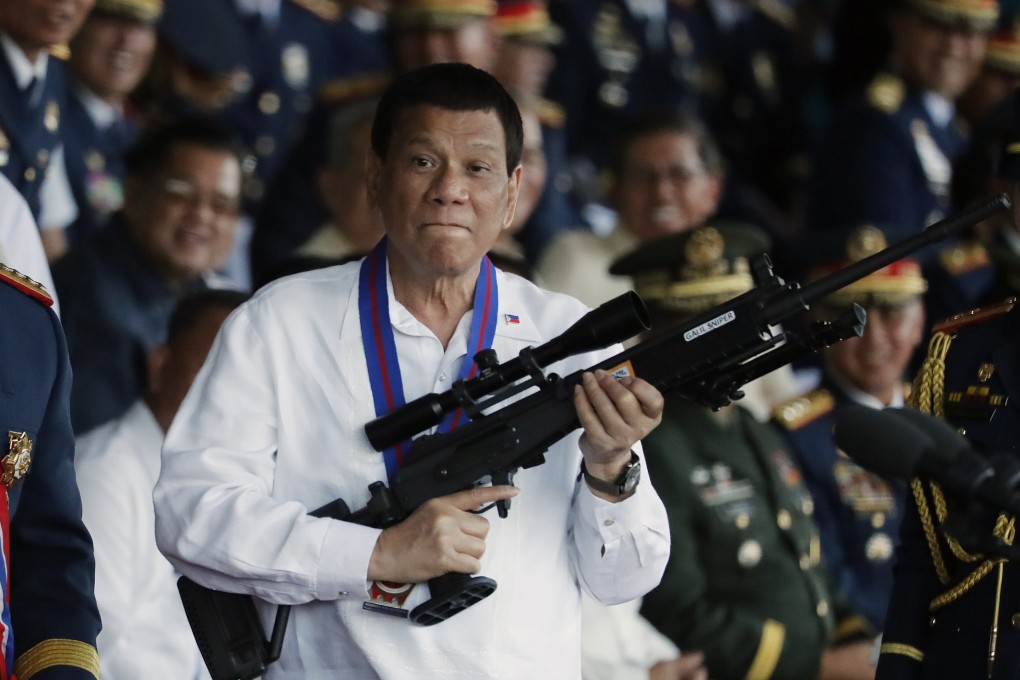Philippine President Rodrigo Duterte with a sniper rifle in Quezon city. Photo: EPA