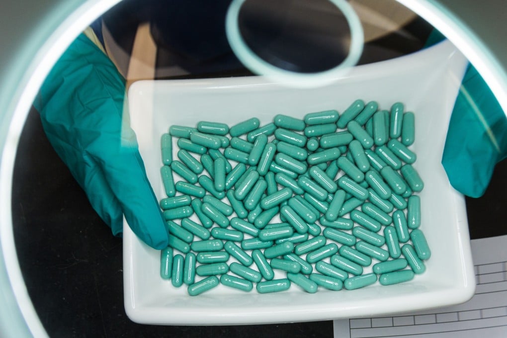 An employee checks the production of capsules at a Stada Arzneimittel durg manufacturing facility in Germany. Photo: dpa