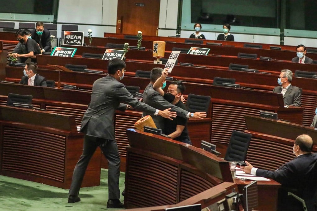 Legislative Council security guards tackle Raymond Chan after he left his seat during the debate on the national anthem law. Photo: Nora Tam