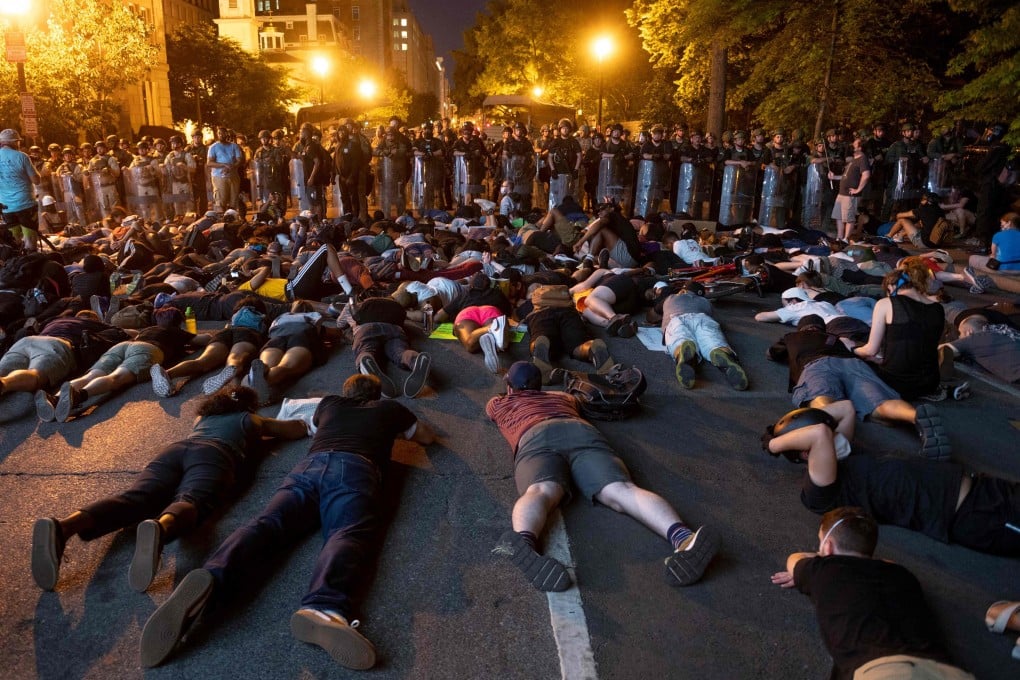 Demonstrators lay on the ground facing a police line in front of the White House on Wednesday during protests over the death of George Floyd. Photo: AFP