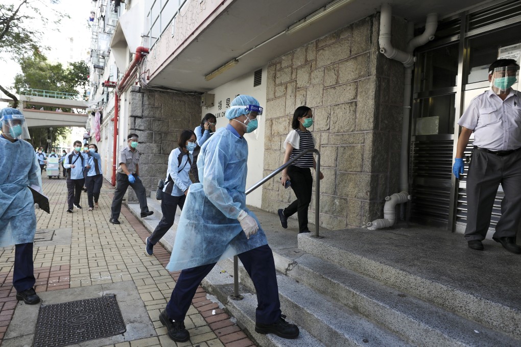 Officials wearing protective gear enter Luk Chuen House, Lek Yuen Estate, in Sha Tin. Photo: Xiaomei Chen