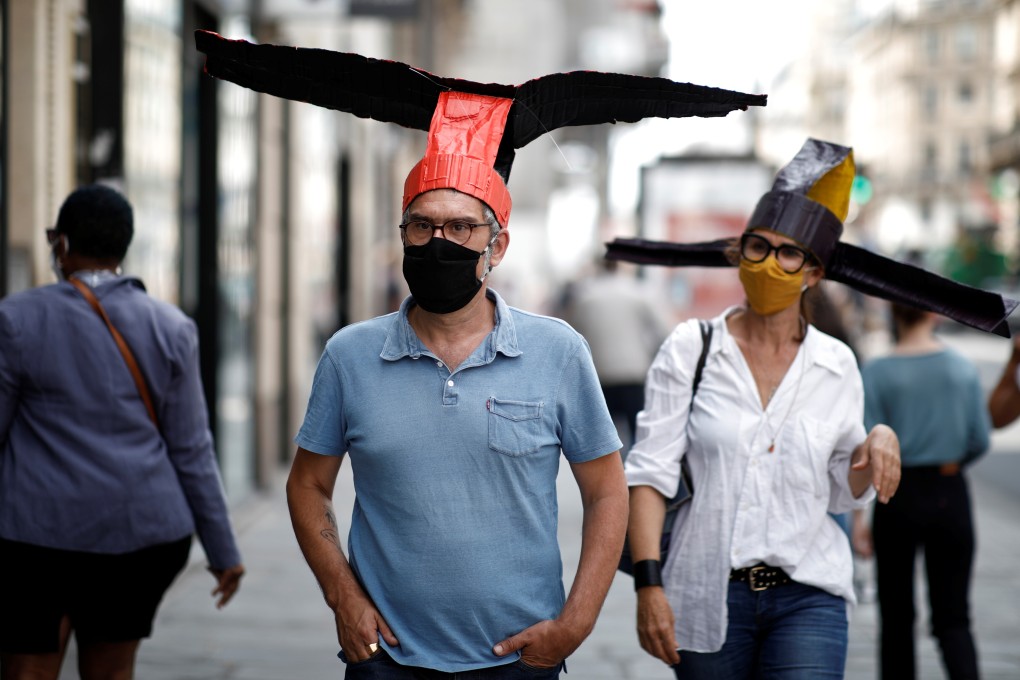 Artists wear papier-mâché hats modelled on headgear the first emperor of China’s Song dynasty made his officials wear, which Parisian art gallery 59 Rivoli is handing out to visitors to enforce social distancing rules amid the coronavirus pandemic. Photo: Reuters