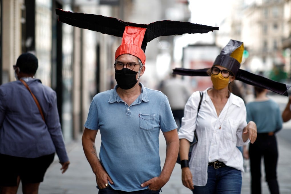 Artists wear papier-mâché hats modelled on headgear the first emperor of China’s Song dynasty made his officials wear, which Parisian art gallery 59 Rivoli is handing out to visitors to enforce social distancing rules amid the coronavirus pandemic. Photo: Reuters