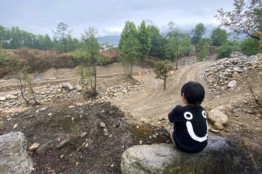 A boy sits beside one of the creeks that was turned into a construction site as part of a project to improve water quality. Photo: Handout