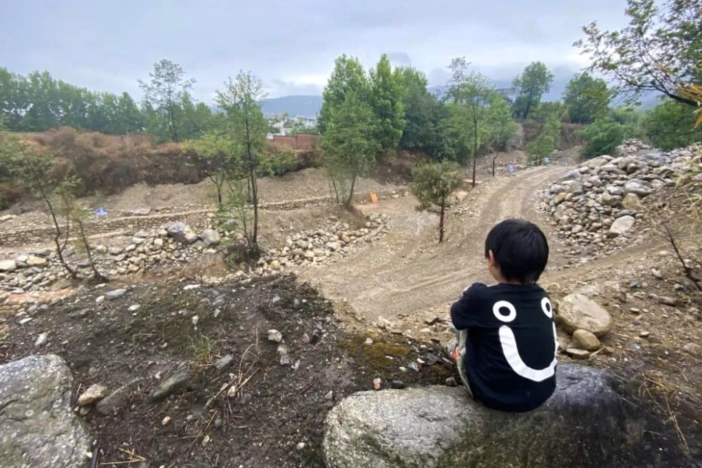 A boy sits beside one of the creeks that was turned into a construction site as part of a project to improve water quality. Photo: Handout