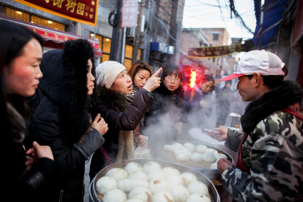 Women buy steamed buns from a street vendor in the old town of Luoyang, Henan province. Photo: Reuters