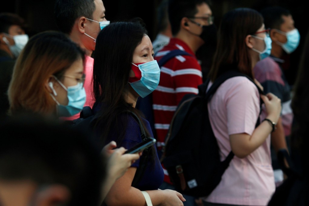 People cross a street during the morning peak-hour commute in Singapore on June 3. Photo: Reuters