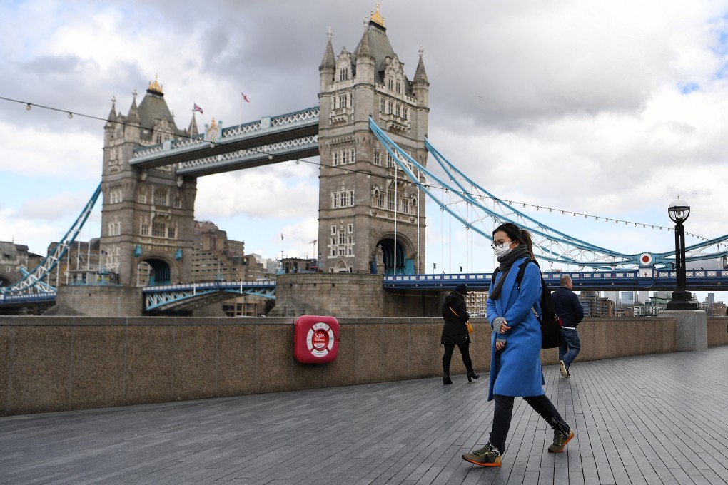 A woman wearing a face mask walks past Tower Bridge in London on March 12. Microsoft Corp, Amazon Web Services and Google are also involved in the health data deal made between Palantir Technologies and Britain’s National Health Service. Photo: EPA-EFE