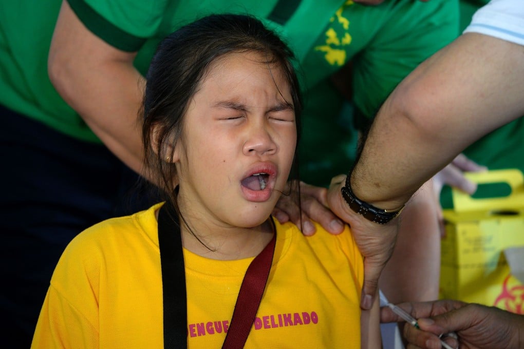 A Philippine student grimaces as a nurse administers an anti-dengue vaccine. Photo: AFP