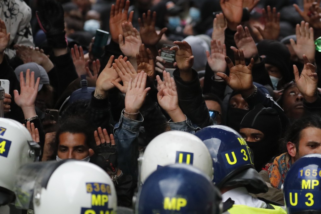 Protesters raise their hands as they confront police during a protest rally in London. Europeans joined the global wave of anti-racism protests on Sunday. Photo: AP