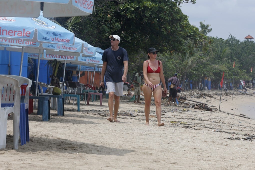 Foreigners walk along an empty Kuta Beach in Bali amid the coronavirus pandemic in March. Photo: AP