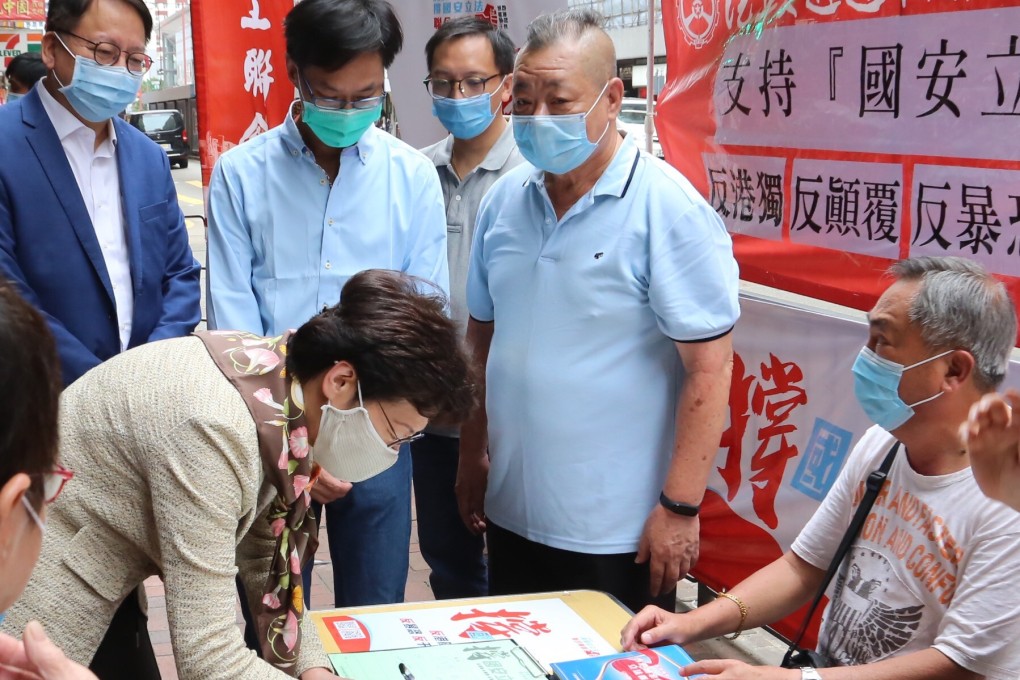 Chief Executive Carrie Lam signs a petition in support of the national security legislation for Hong Kong, as she visits a street stand on May 28. Photo: Xinhua