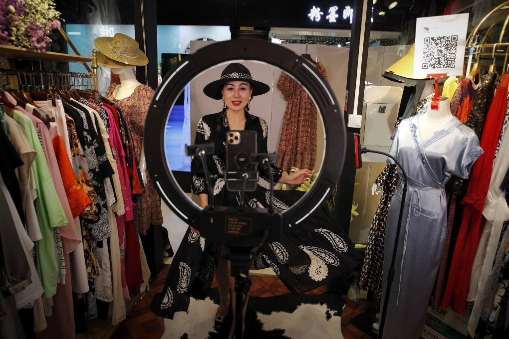 In this April 27, 2020, photo, Song Huiyan shows her fashion dresses for her online clients during the live-streaming at her clothing shop in Beijing. Photo: AP