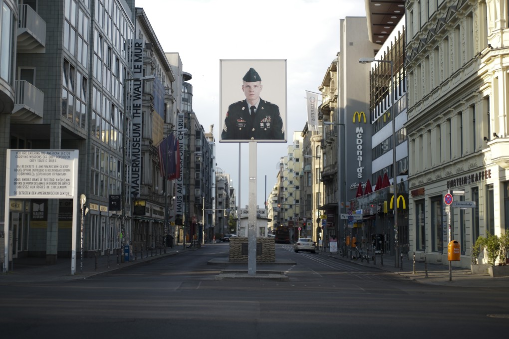 A picture of a former US soldier is displayed at the former US army Checkpoint Charlie in Berlin, Germany. US President Donald Trump is said to have signed off on a plan to reduce the number of troops stationed in Germany from 34,500 to no more than 25,000. Photo: AP