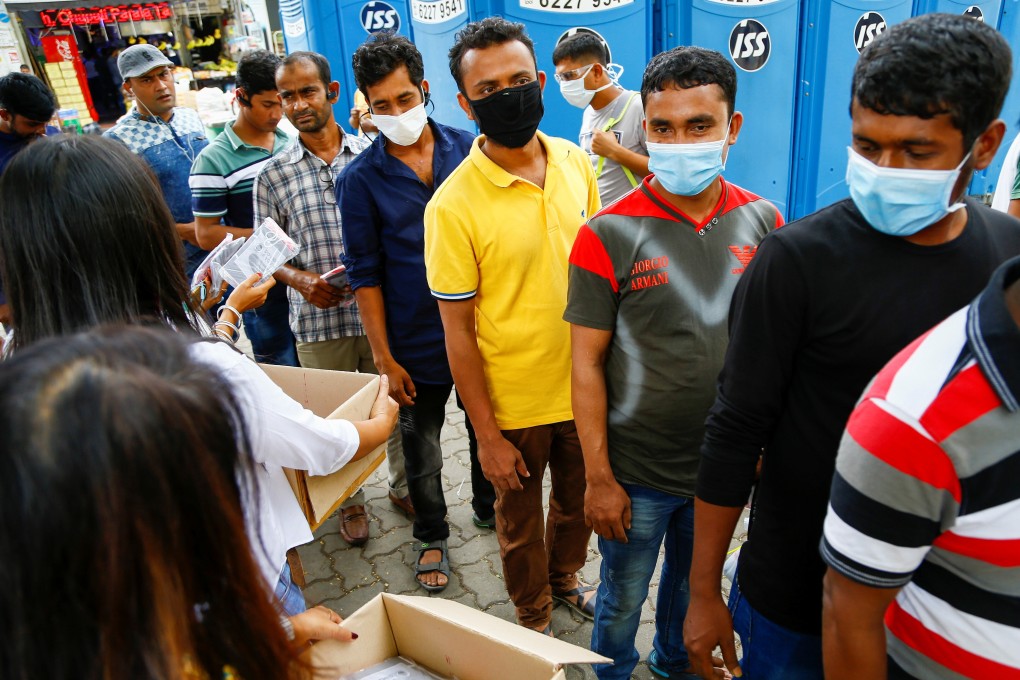 Migrant workers, mostly from Bangladesh, queue to collect free masks and get their temperatures taken in Singapore. Photo: Reuters