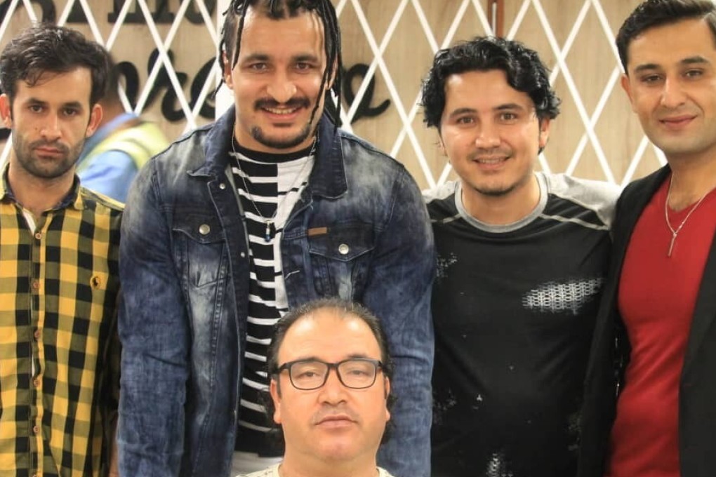 Ezatullah Kakar (second left) with fellow refugees at the Port Moresby airport as he prepares to leave for the United States. Photo: Handout