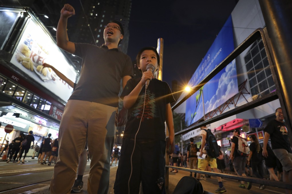 A father (left) and son chant slogans during a protest through Wan Chai in Hong Kong last year. There is a need for schools, parents and policymakers to work out how best to discuss the global protests in the classroom. Photo: James Wendlinger