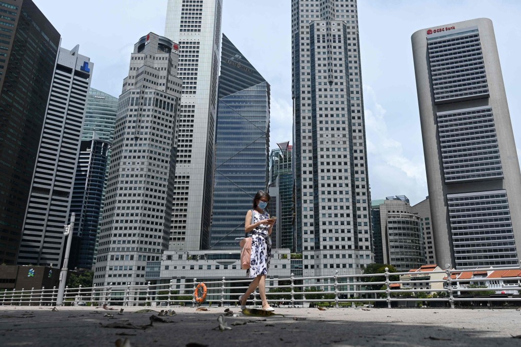 A woman walks past buildings in Singapore’s central business district on June 11, 2020. Photo: AFP